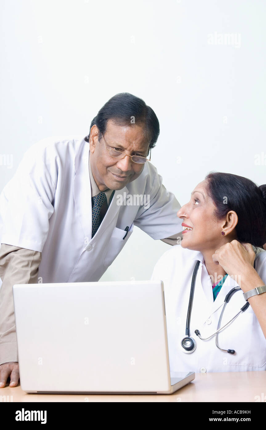 Femme médecin avec un médecin homme en face d'un ordinateur portable Banque D'Images