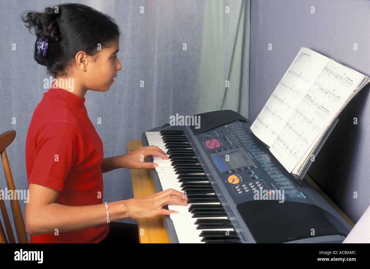 Teenage girl playing son clavier Banque D'Images