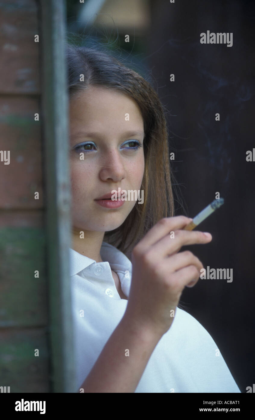 Teenage girl cigarette derrière shed Banque D'Images