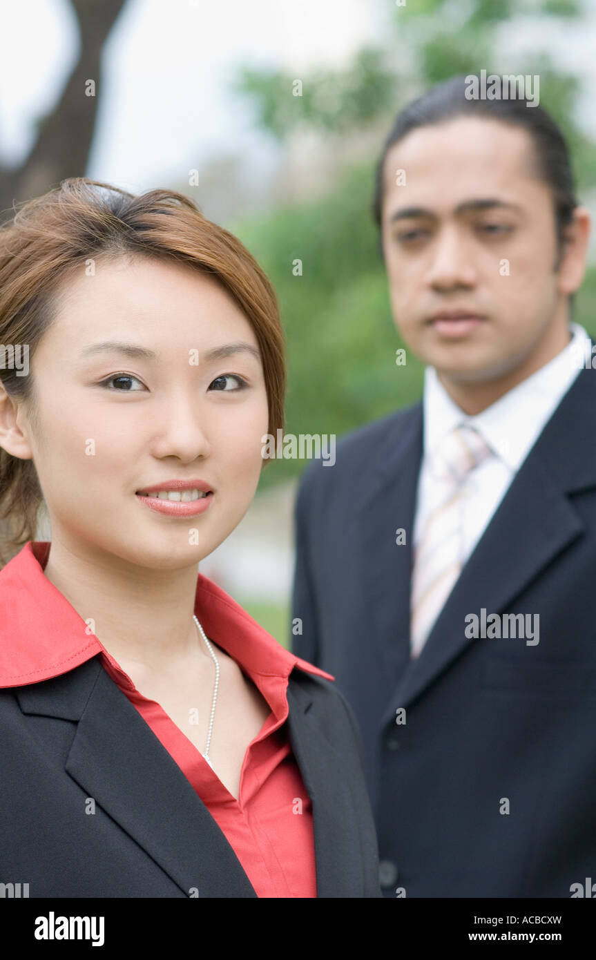 Portrait of a businesswoman smiling avec un homme debout à côté de sa Banque D'Images