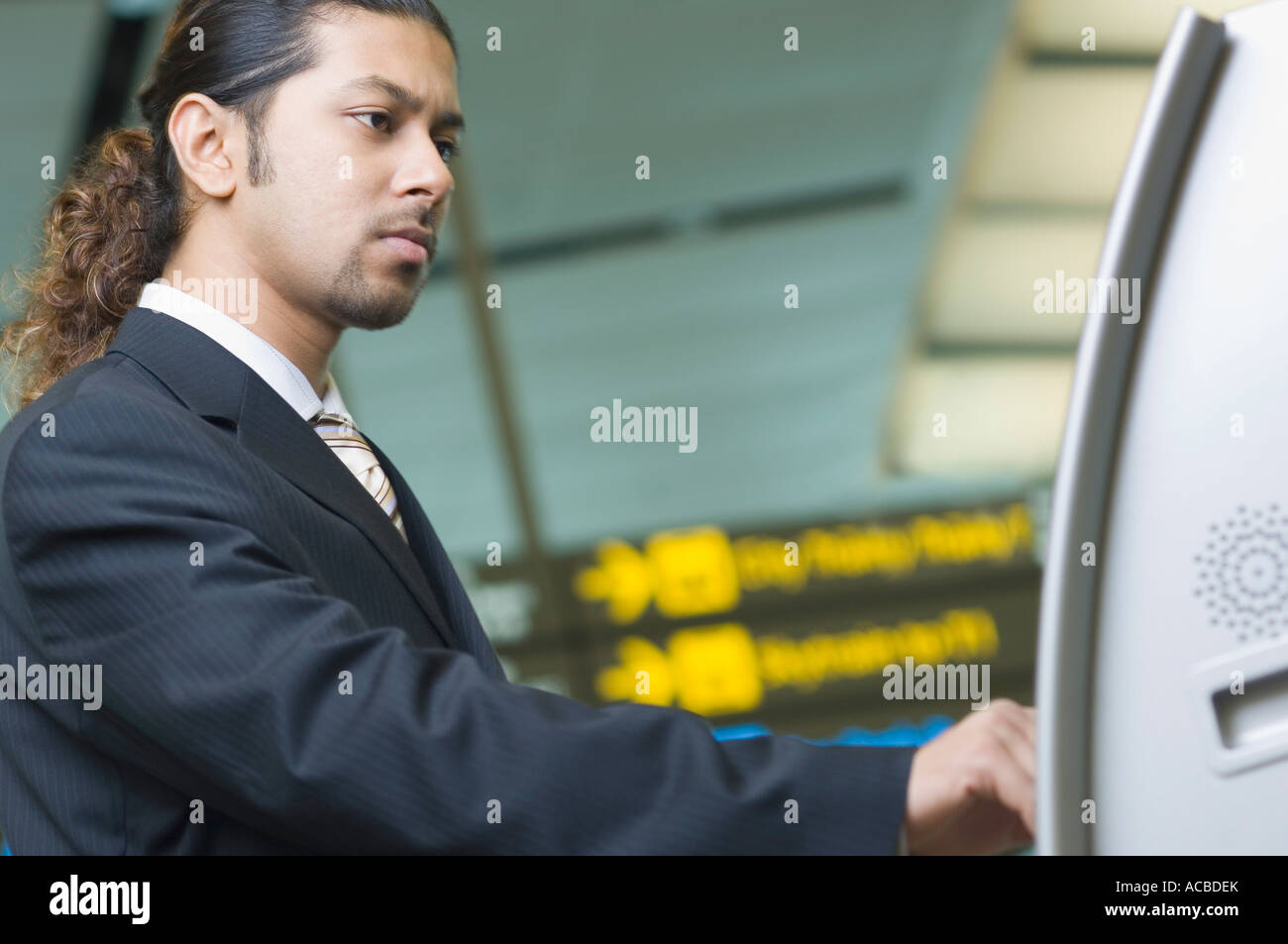 Portrait d'un homme d'affaires à l'aide d'une machine automatique de billets Banque D'Images