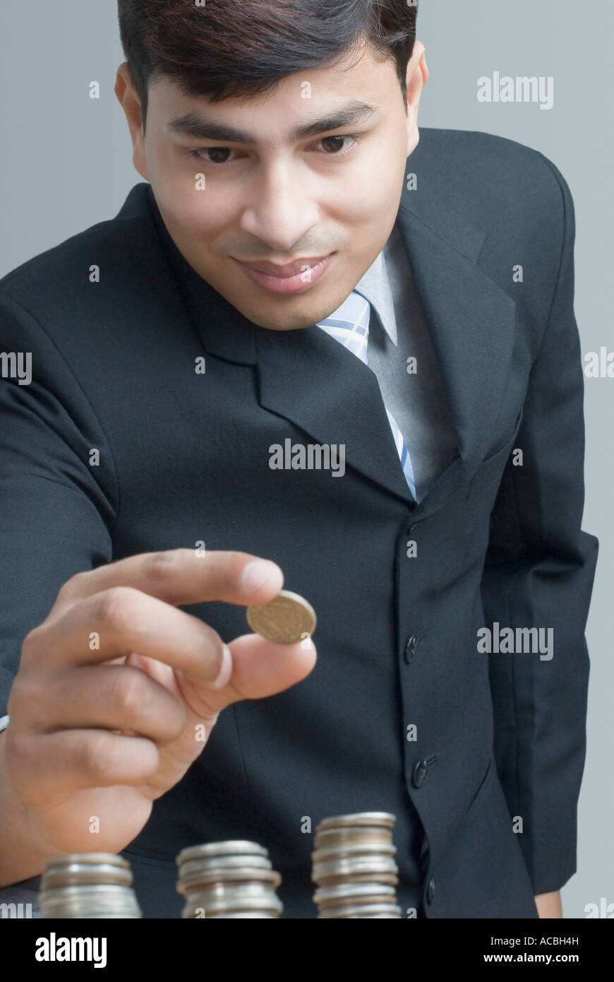 Close-up of a businessman holding un Indien coin sur les tas de coin Banque D'Images