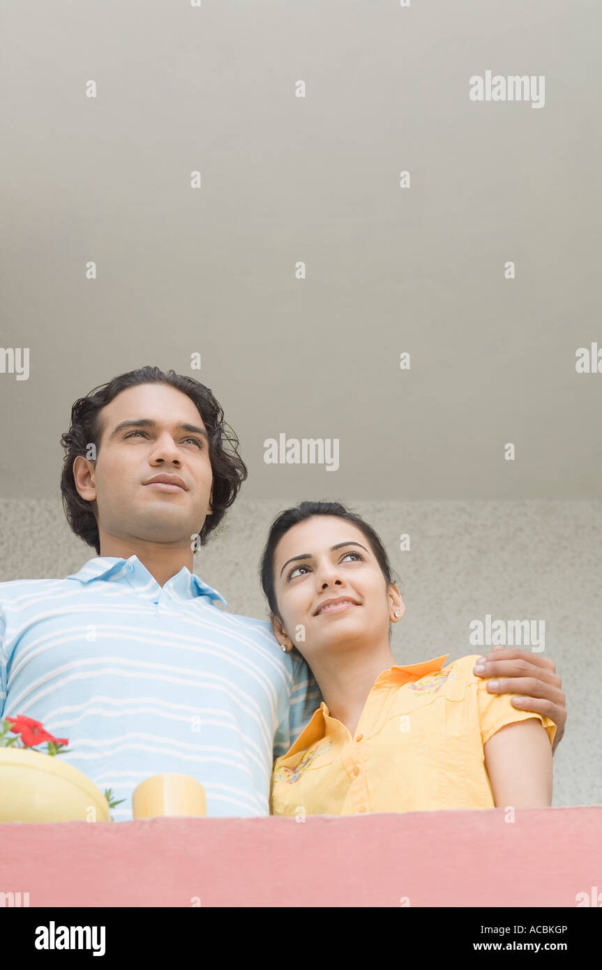 Low angle view of a young couple debout dans un balcon Banque D'Images