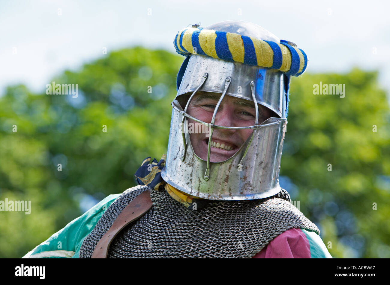 Homme habillé comme un chevalier et souriant à une reconstitution historique adoption Banque D'Images