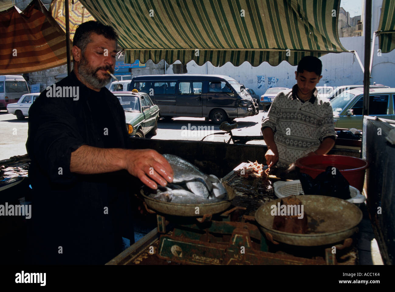 Des marchands de poisson pesant et préparer un poisson dans le marché, Saïda, Liban Banque D'Images