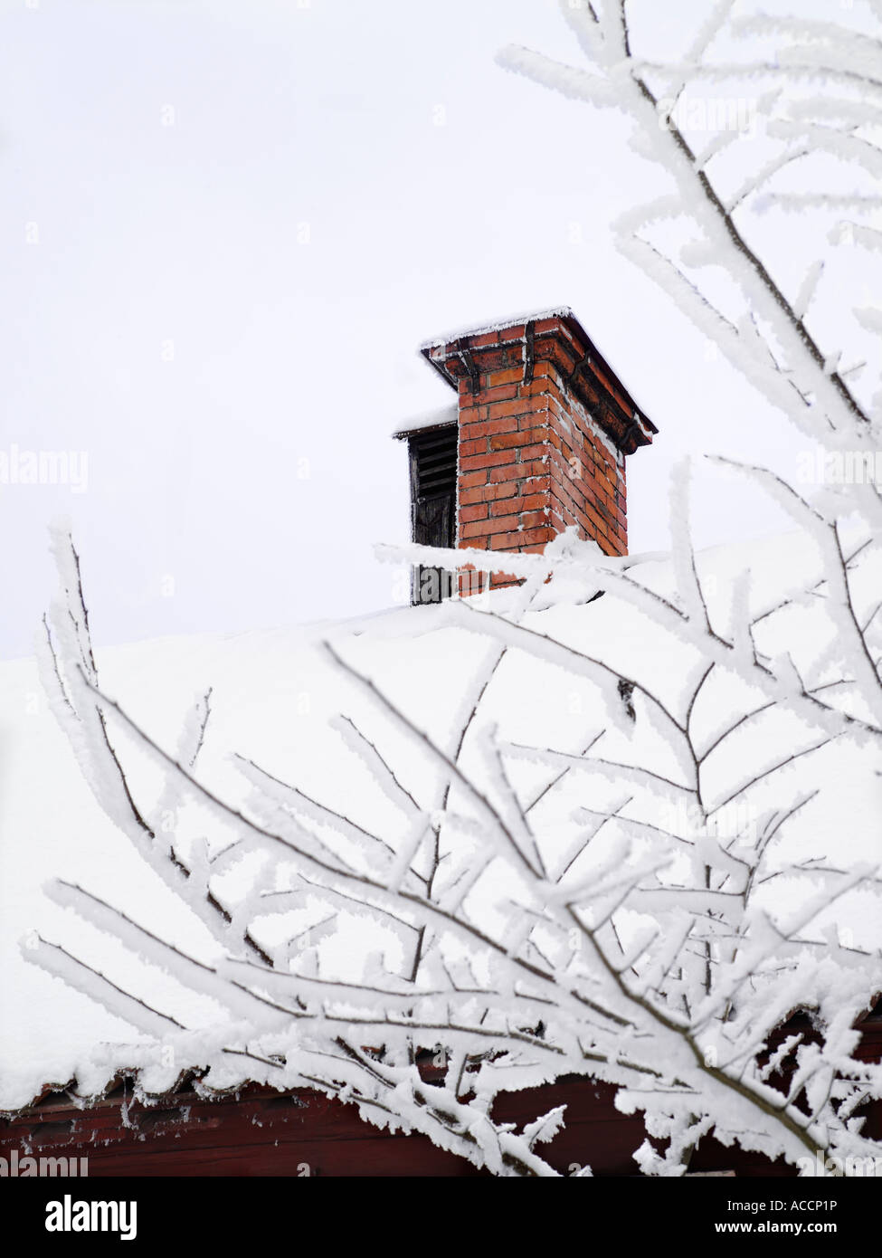 Une cheminée sur un toit recouvert de neige. Banque D'Images