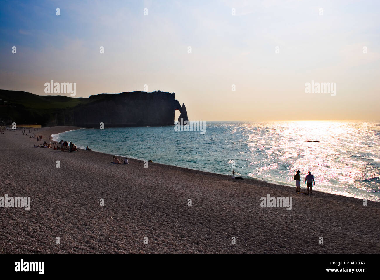 Silhouette de l'orifice de l'aiguille et la falaise de personnes sur la plage d'Etretat France au coucher du soleil Banque D'Images