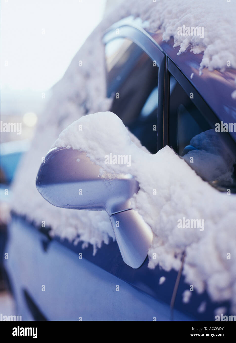 Un miroir sur une voiture couverte de neige. Banque D'Images