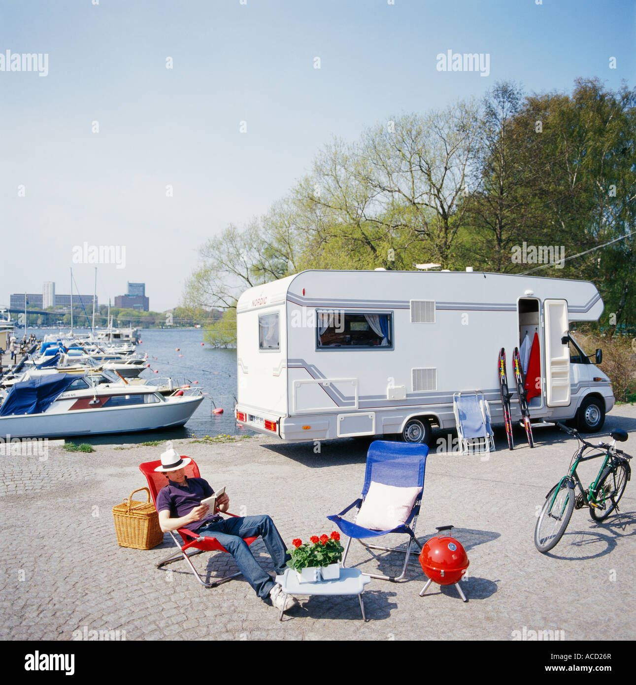 La lecture d'un homme en face d'une caravane. Banque D'Images