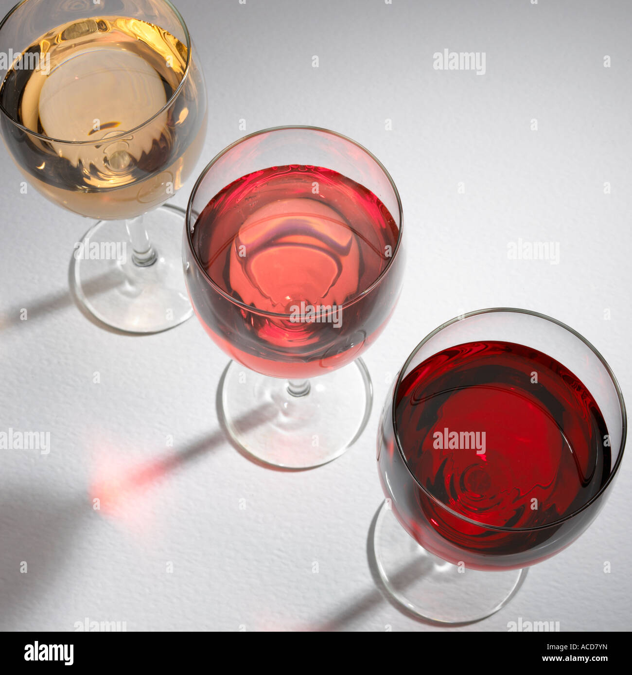 Trois verres de vin CONTENANT DU VIN ROUGE ET ROSE BLANCHE Banque D'Images