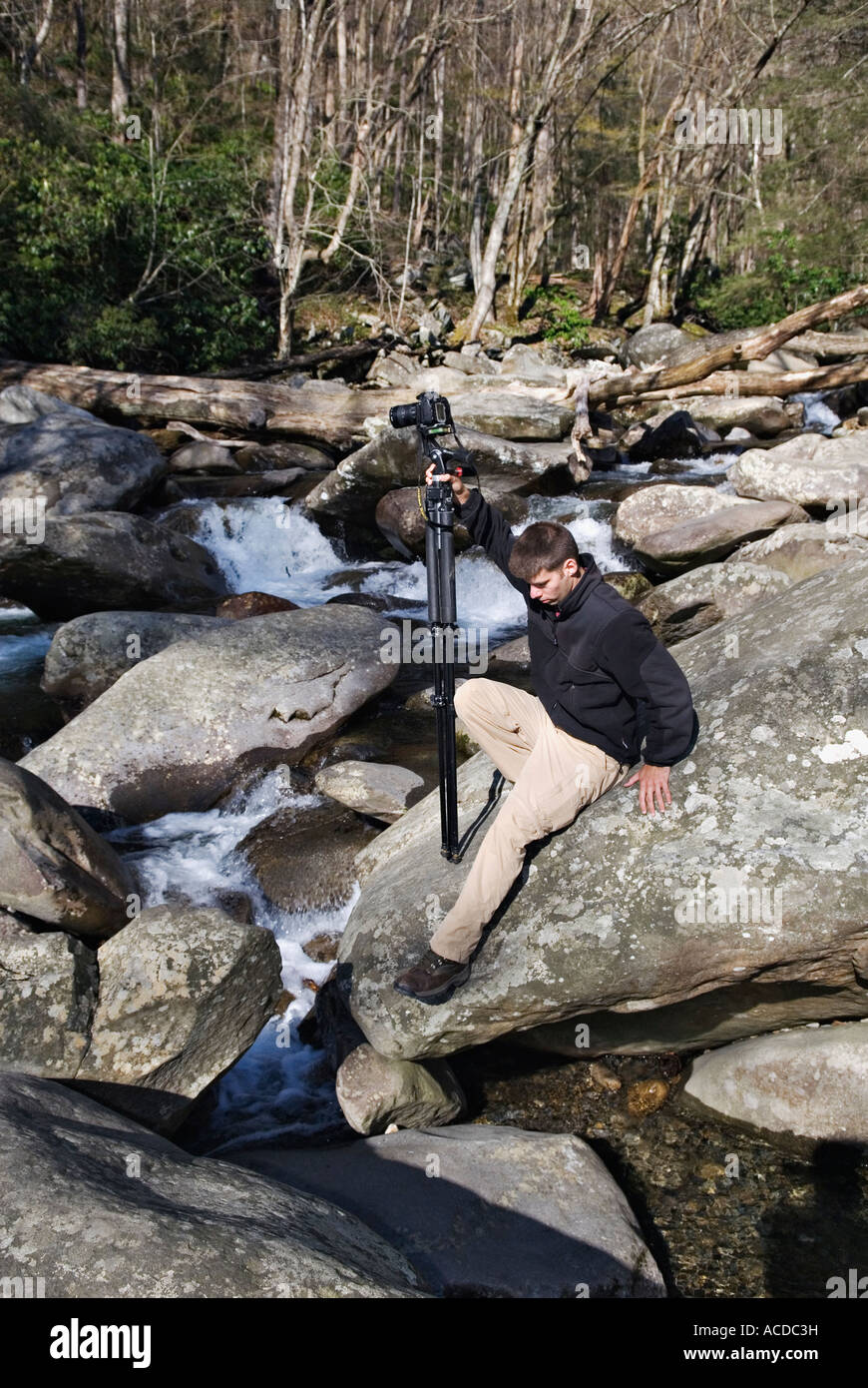 Jeune photographe outdoor caméra sur trépied et la négociation de blocs rocheux à côté de Stream Great Smoky Mountains National Park Banque D'Images