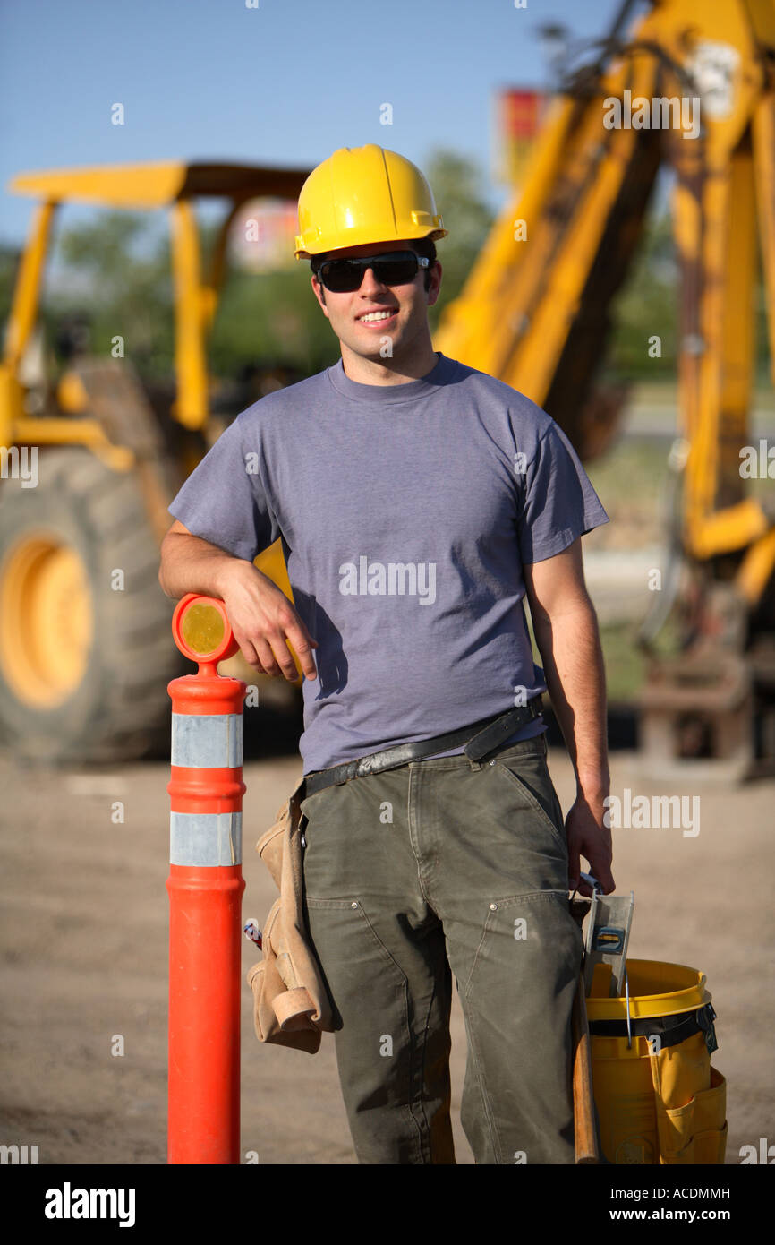 Construction worker par cône avec en arrière-plan de l'équipement Banque D'Images
