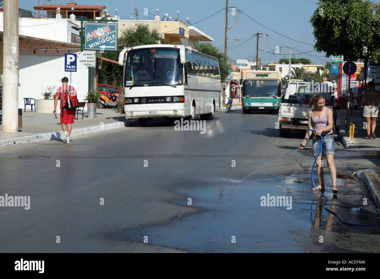 Nettoyage de la femme à l'extérieur de la rue une boutique dans le village de Platanias, Crète, Grèce. Banque D'Images