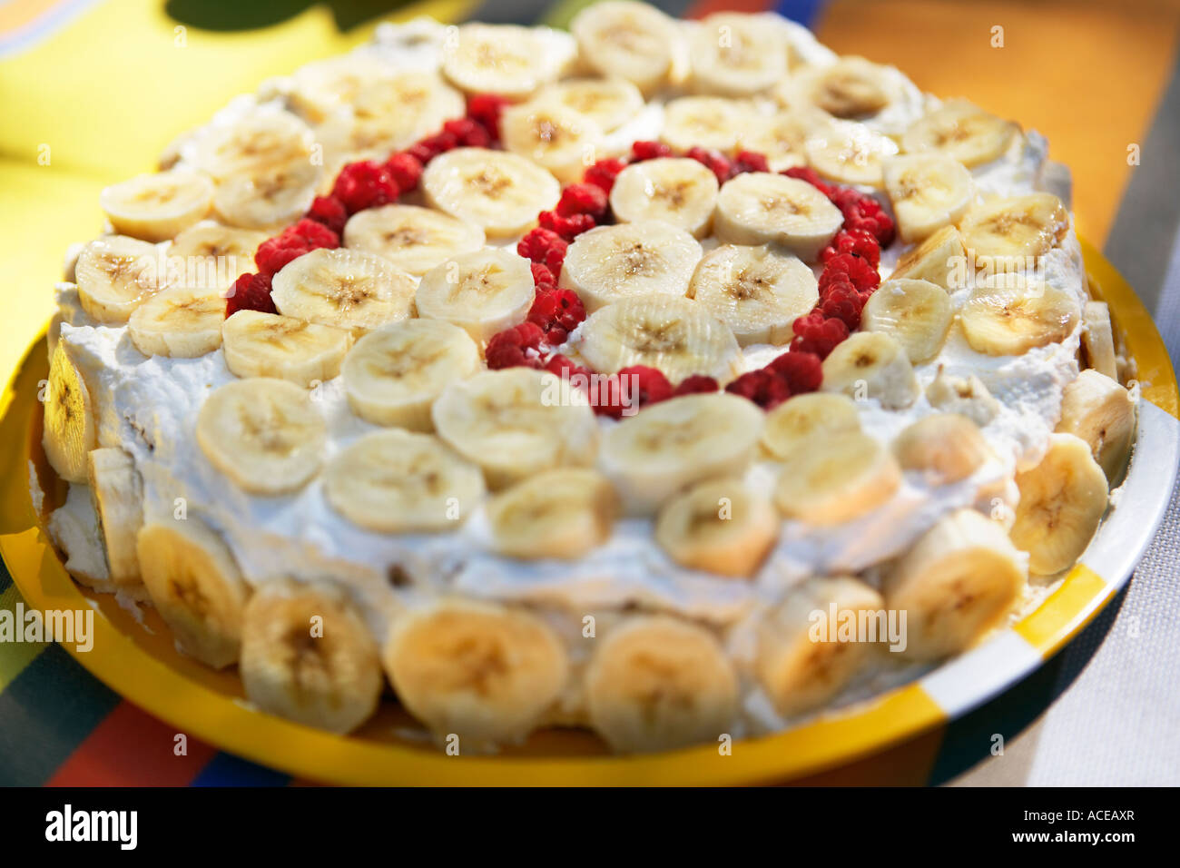Un gâteau avec des tranches de banane et 10 écrit avec des baies. Banque D'Images