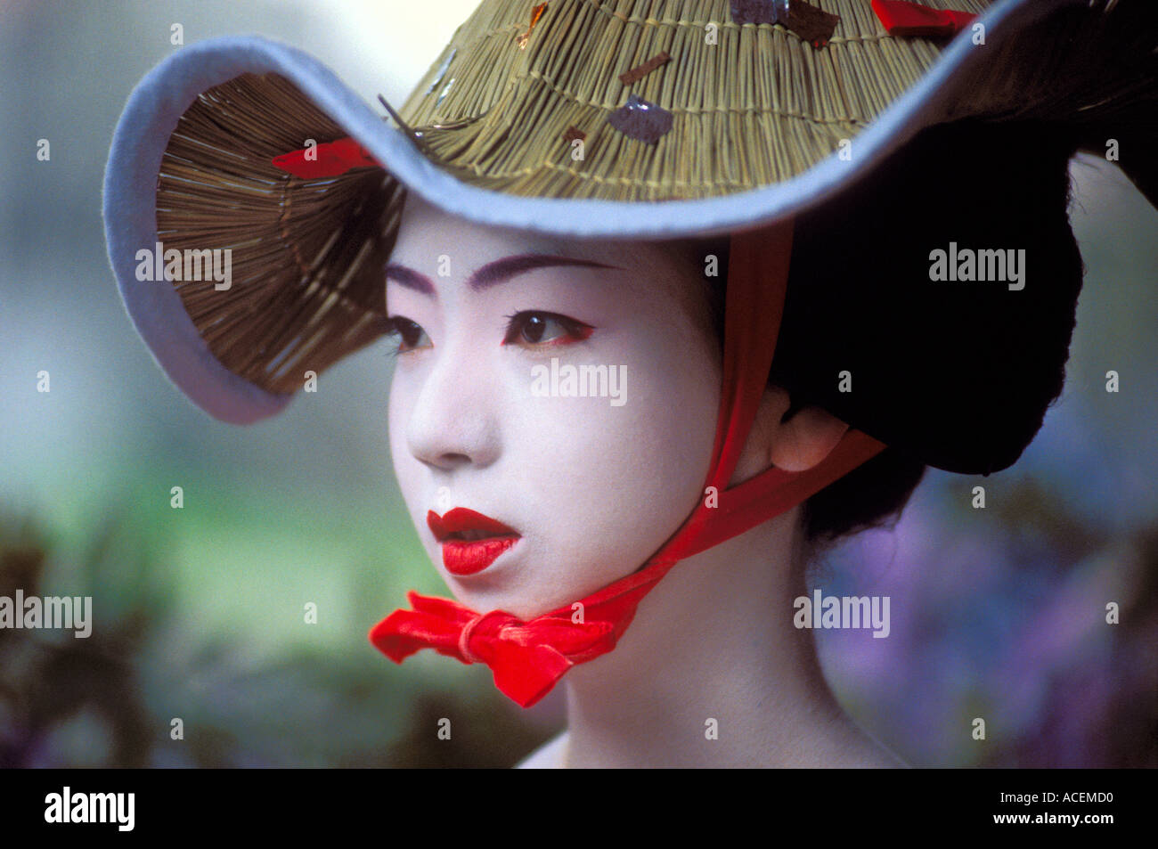 Portrait d'une geisha ou maiko apprenti avec poudre brillant visage blanc portant un chapeau de paille festival Banque D'Images