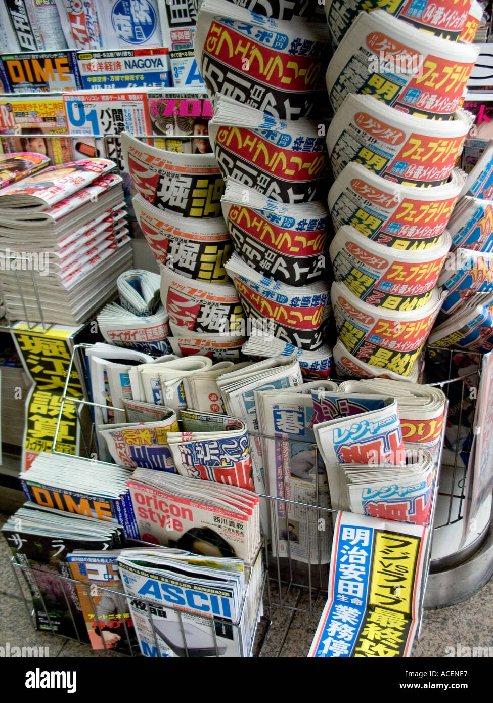 Les journaux japonais soigneusement empilés dans des niveaux à un kiosque à la gare Banque D'Images