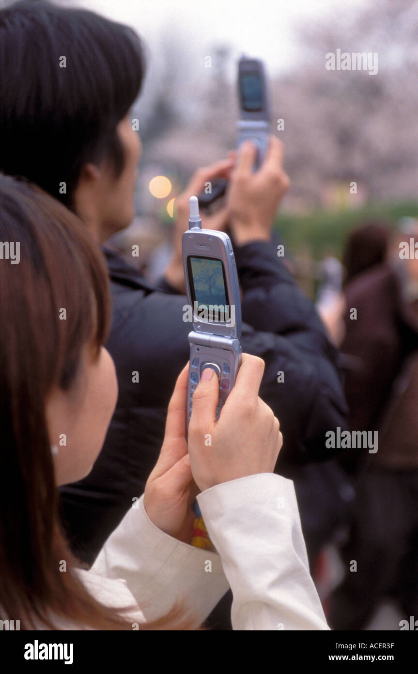 Couple japonais avec la technologie de caméra de téléphone portable capture une scène de printemps au Japon. Banque D'Images