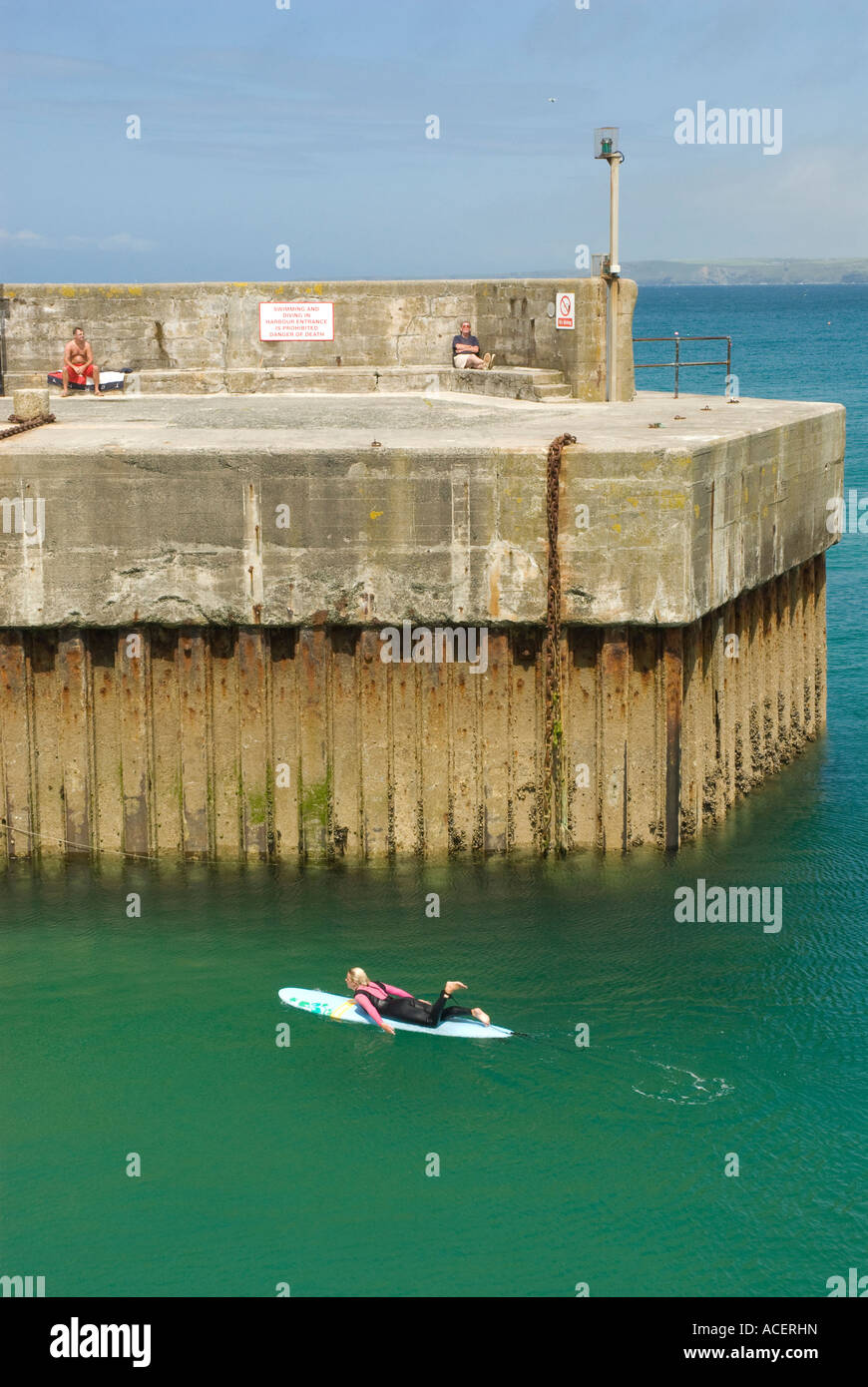Pagayer sur une planche de surf par le quai à Newquay Cornwall Banque D'Images