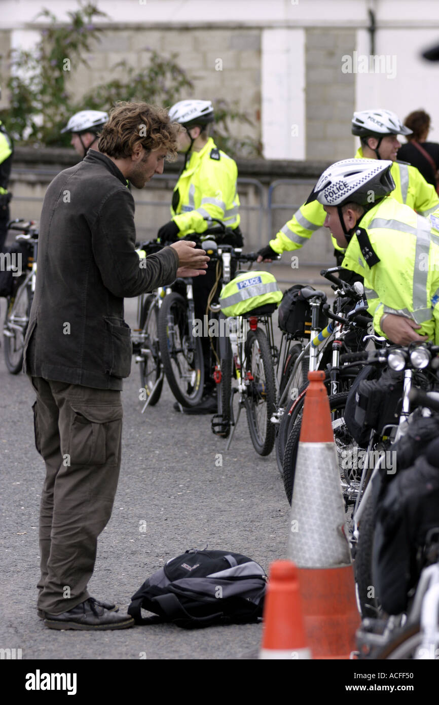 Cycliste avec un manifestant police Banque D'Images