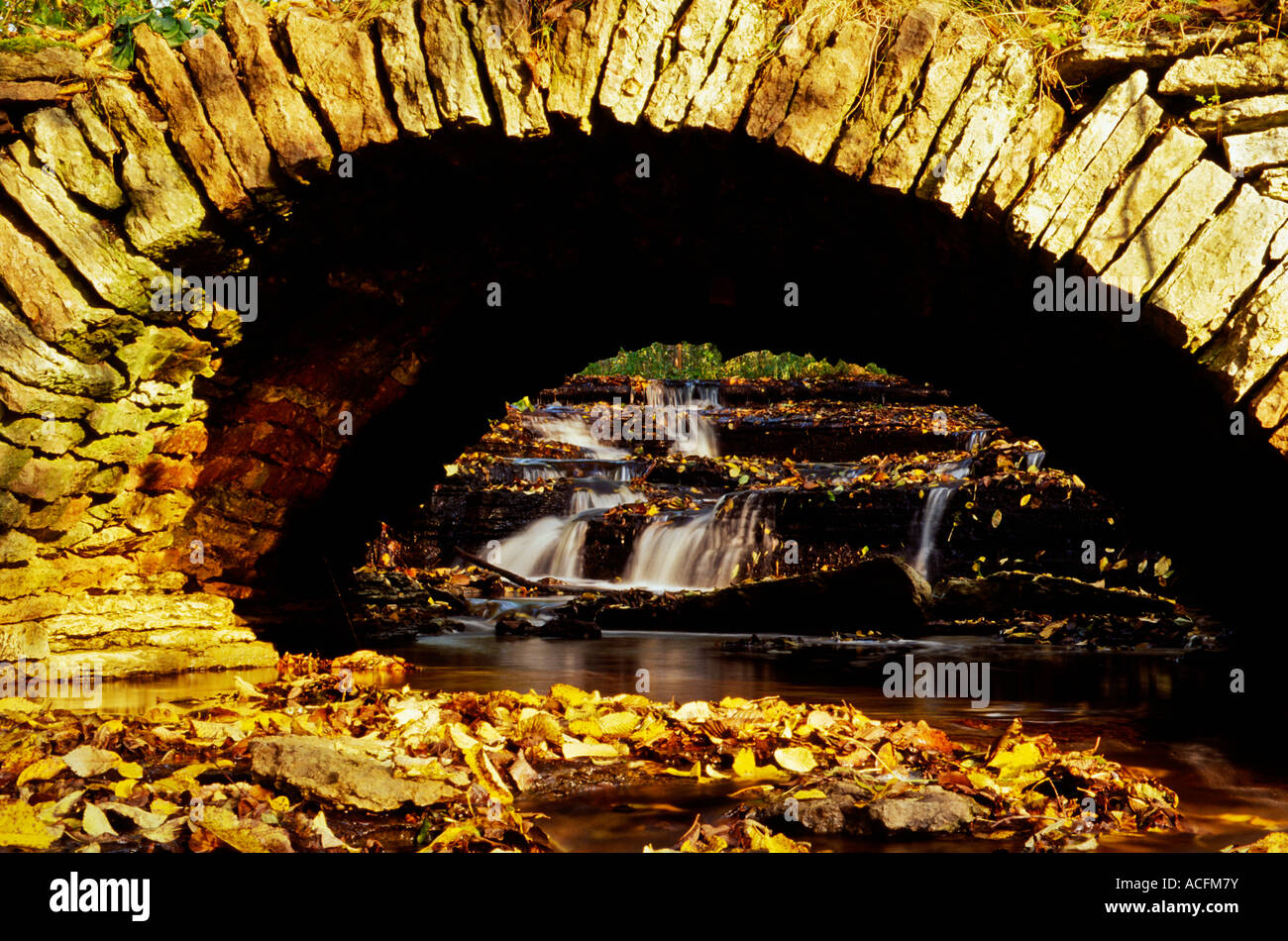 Vieux pont de pierre avec une petite cascade Banque D'Images