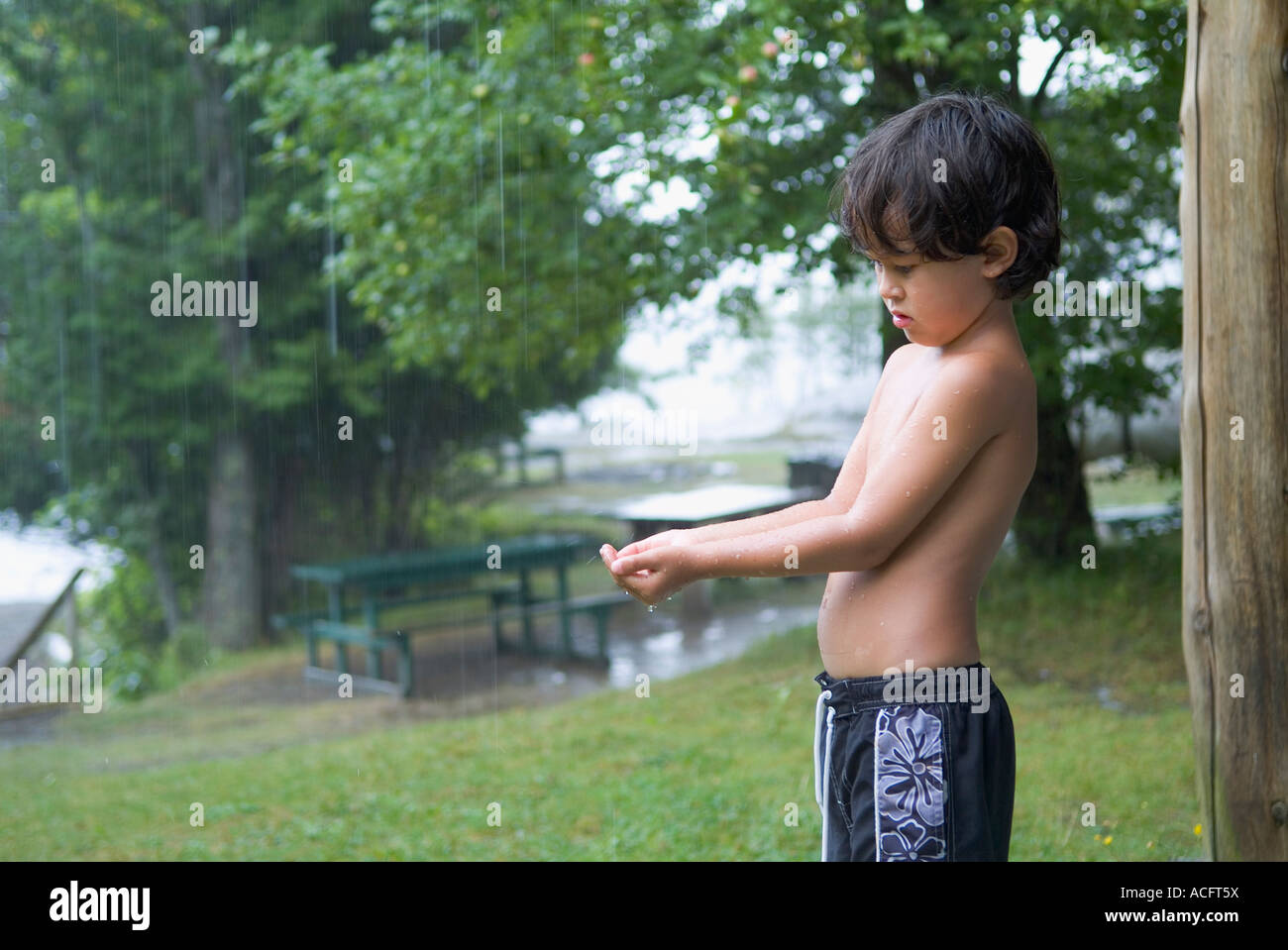 Jeune garçon en maillot de bain attendent d'une pluie de parution du modèle. Banque D'Images
