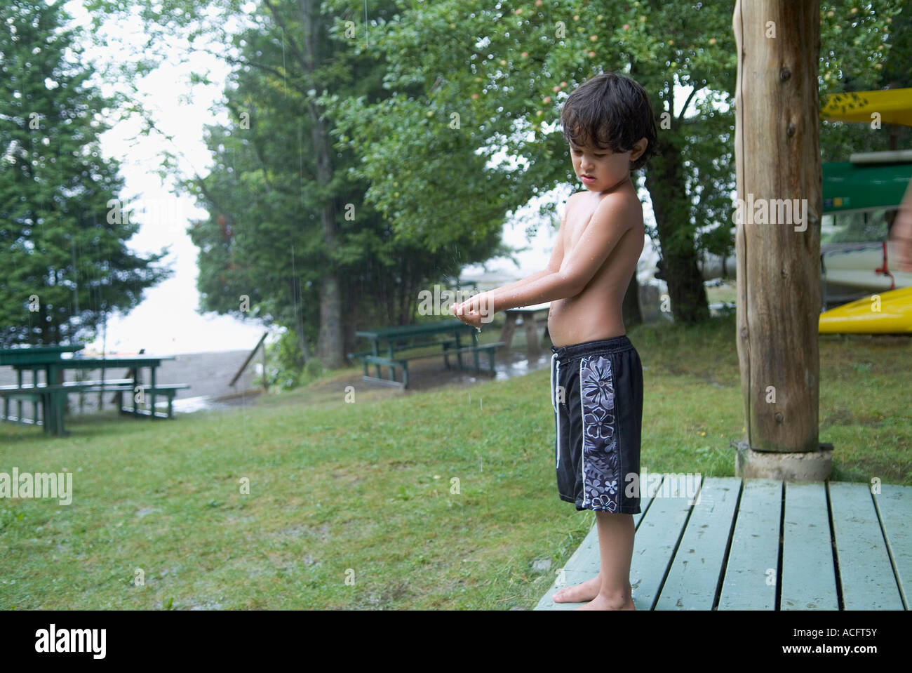 Jeune garçon en maillot de bain attendent d'une pluie Banque D'Images