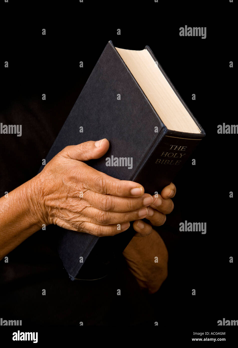 Une vieille femme est titulaire d'une bible dans la prière Banque D'Images