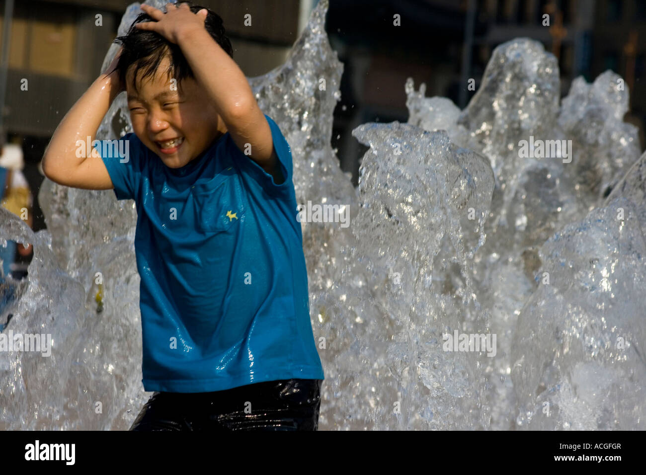 Jeune garçon coréen jouant dans une grande fontaine publique à l'Hôtel de Ville Séoul Corée du Sud Banque D'Images