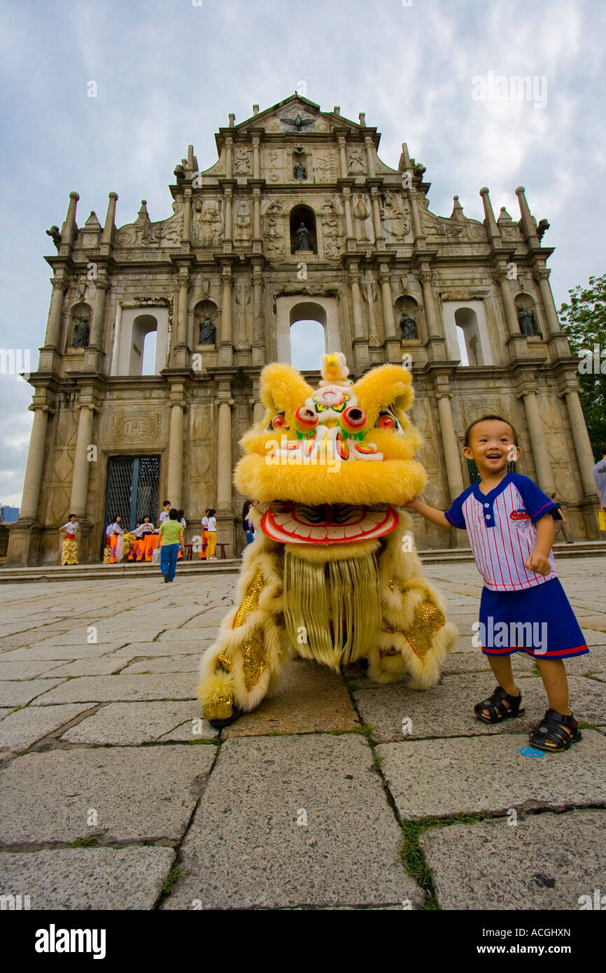 Jeune garçon chinois et danseurs costumés Dragon Les ruines de Sao Paulo ou la Cathédrale Saint Paul à Macao Banque D'Images