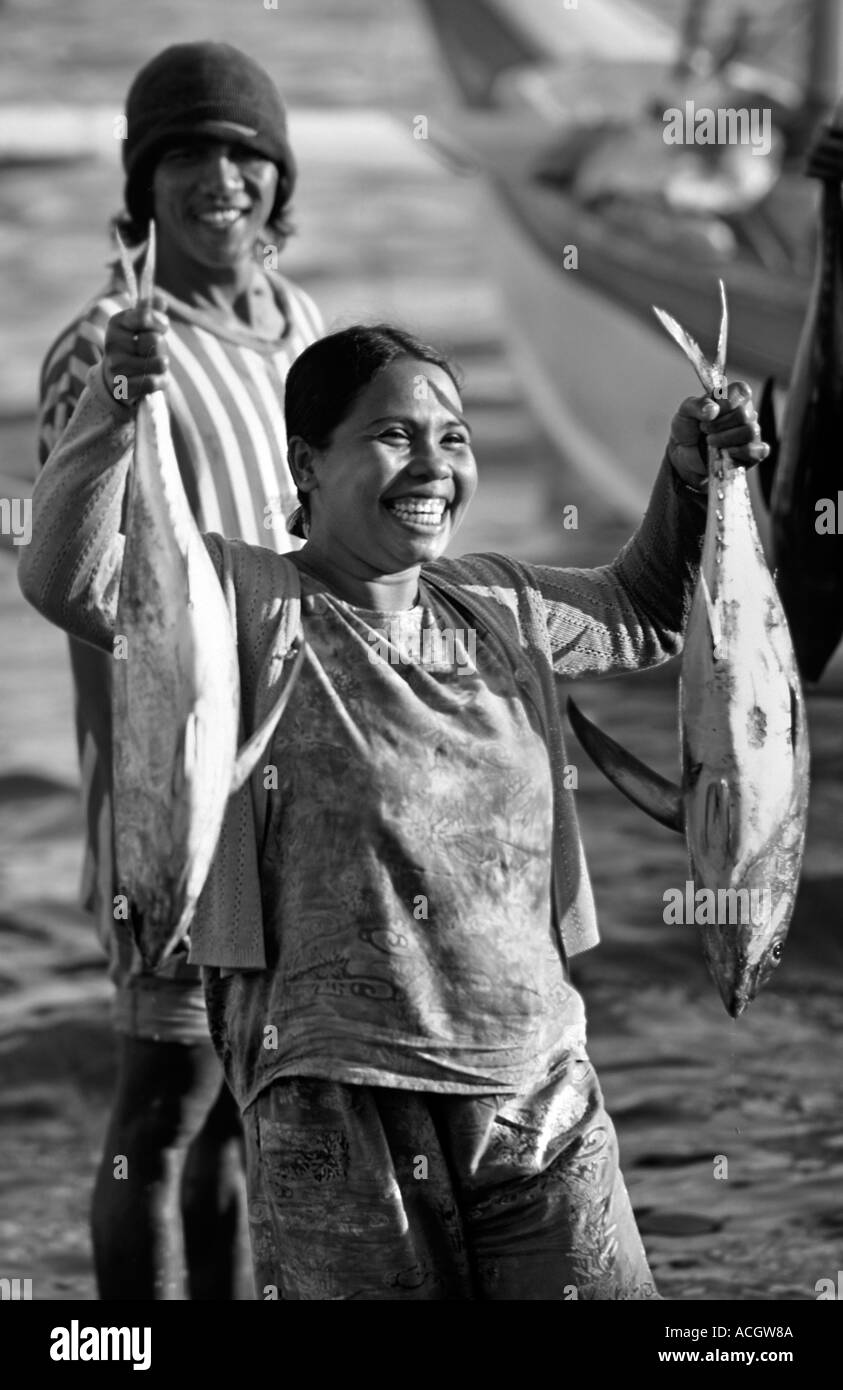 L'expression de joie sur le visage d'un pêcheur balinais s femme tenant une capture réussie Bali Pemuteran s N coast l'Indonésie Banque D'Images