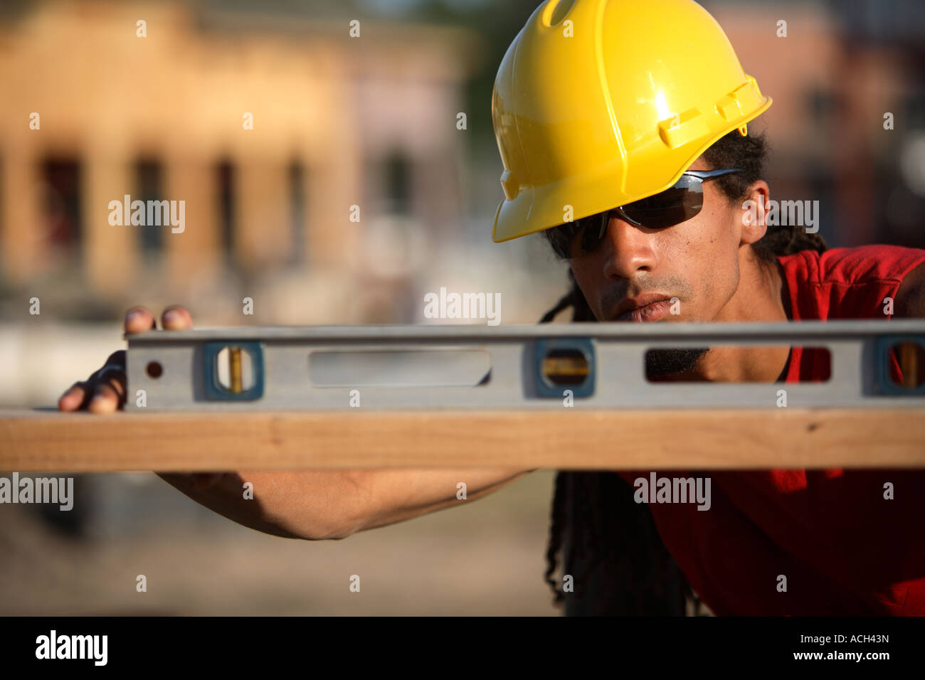 Construction Worker vérifie un niveau Banque D'Images