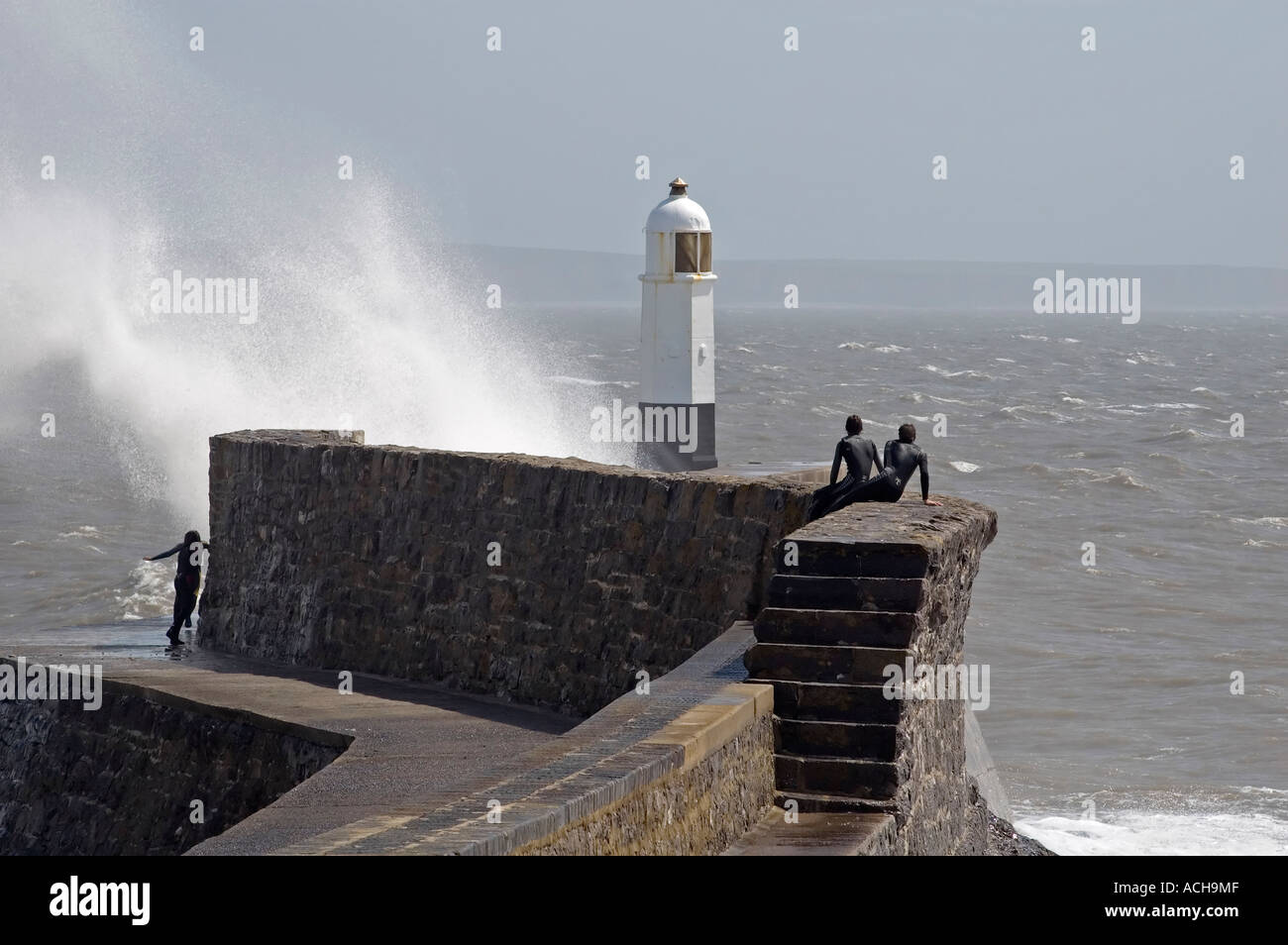 Regarder les surfeurs vagues briser contre le phare de Porthcawl, dans le sud du Pays de Galles, Royaume-Uni. Banque D'Images