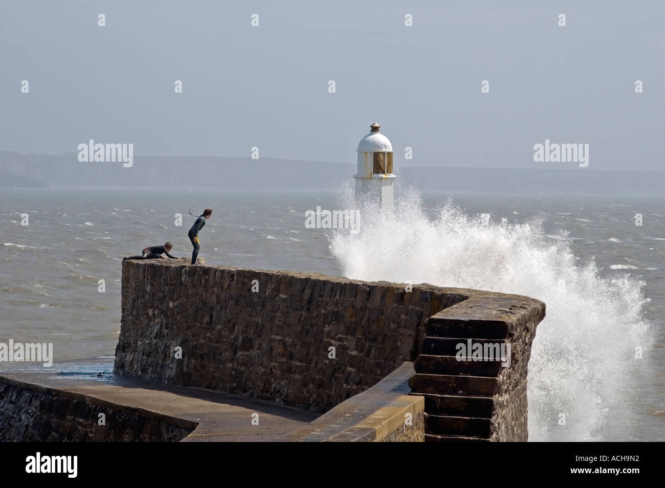 Taunting surfeurs vagues à Porthcawl phare, South Wales UK Banque D'Images