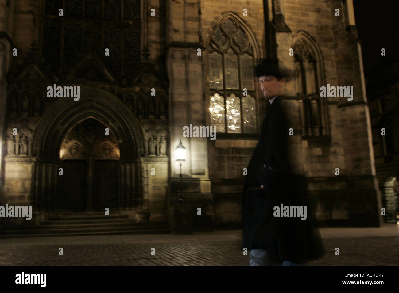 La figure fantomatique d'un homme en passant devant une église de nuit. Banque D'Images