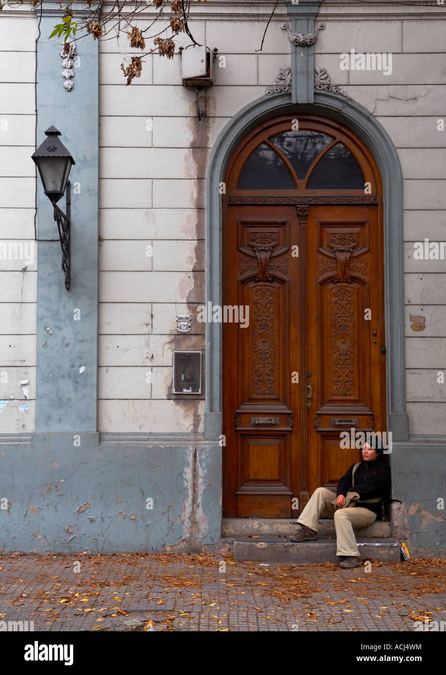 Fille assise sur le pas de la porte de l'ancien bâtiment Banque D'Images
