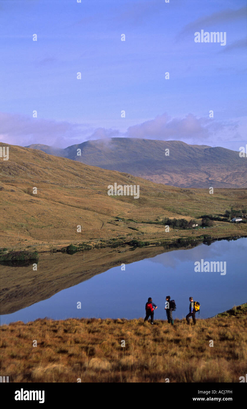 Les randonneurs à la redevance à l'ensemble de Lough Maumturk Mountains, Connemara, comté de Galway, Irlande. Banque D'Images