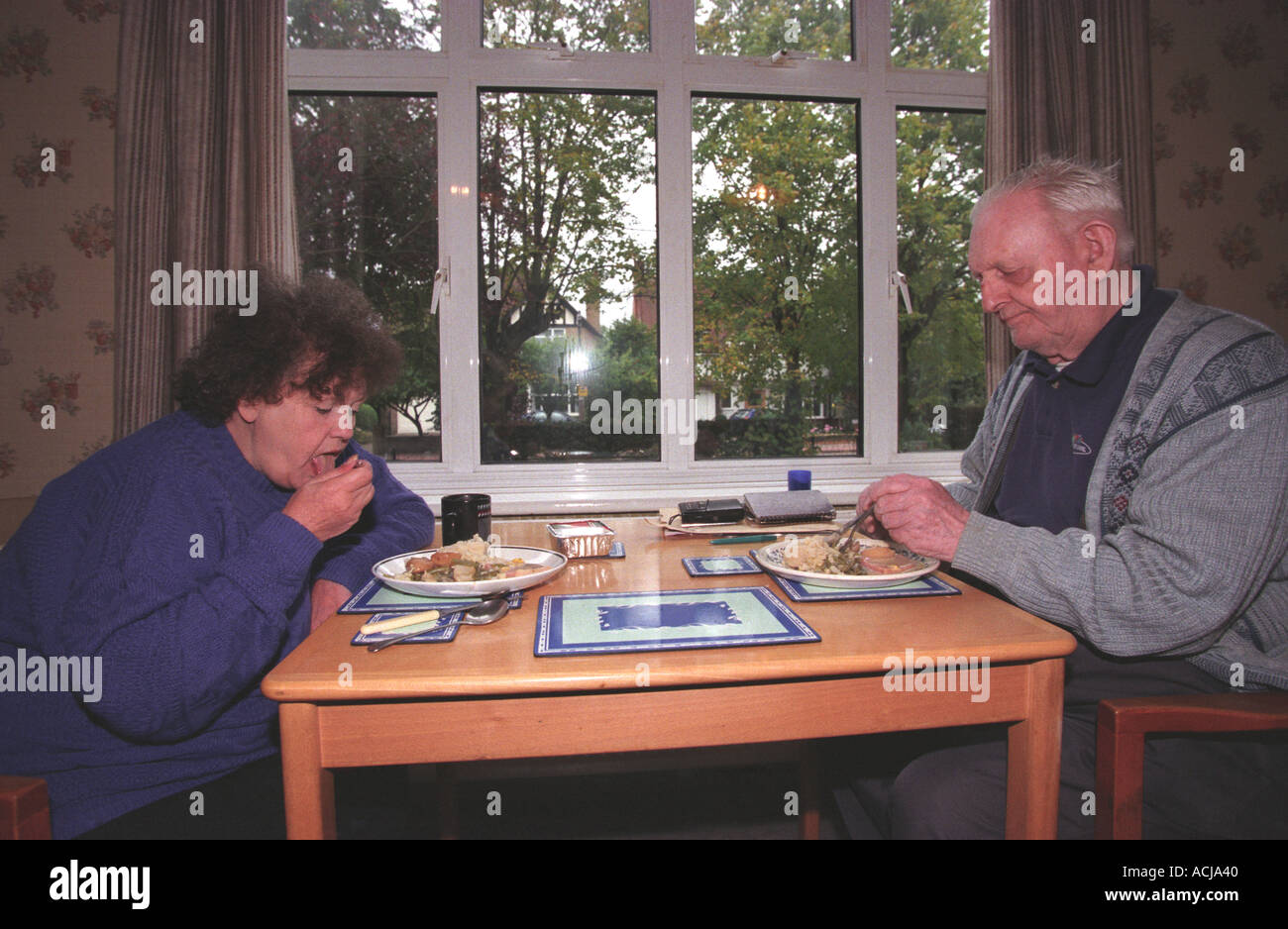 Deux personnes âgées à manger leur repas à domicile fournis par le ministère des services sociaux locaux, Hillingdon, Middlesex UK Banque D'Images