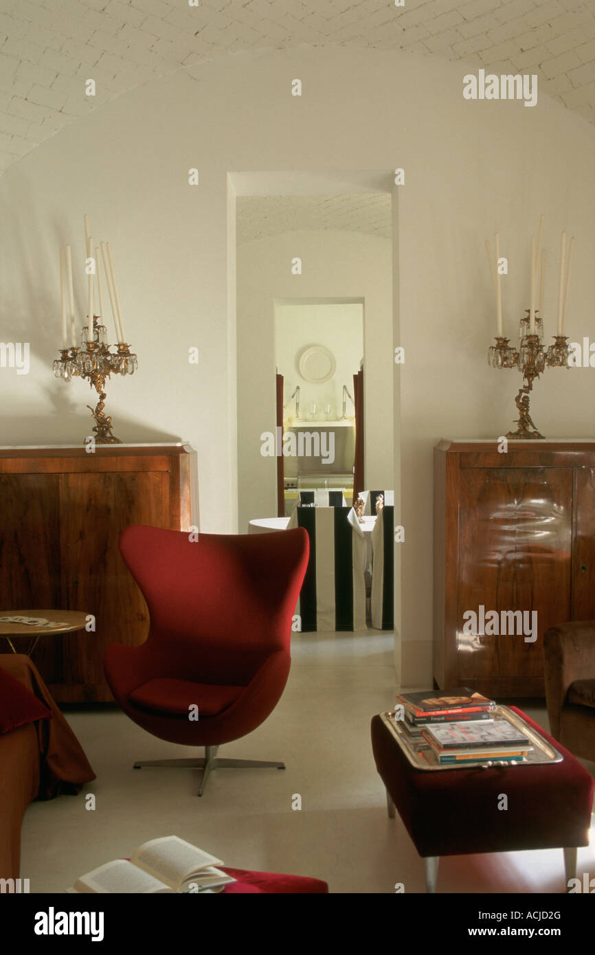 Fauteuils en velours rouge et bancs buffet chandeliers murs blancs Banque D'Images