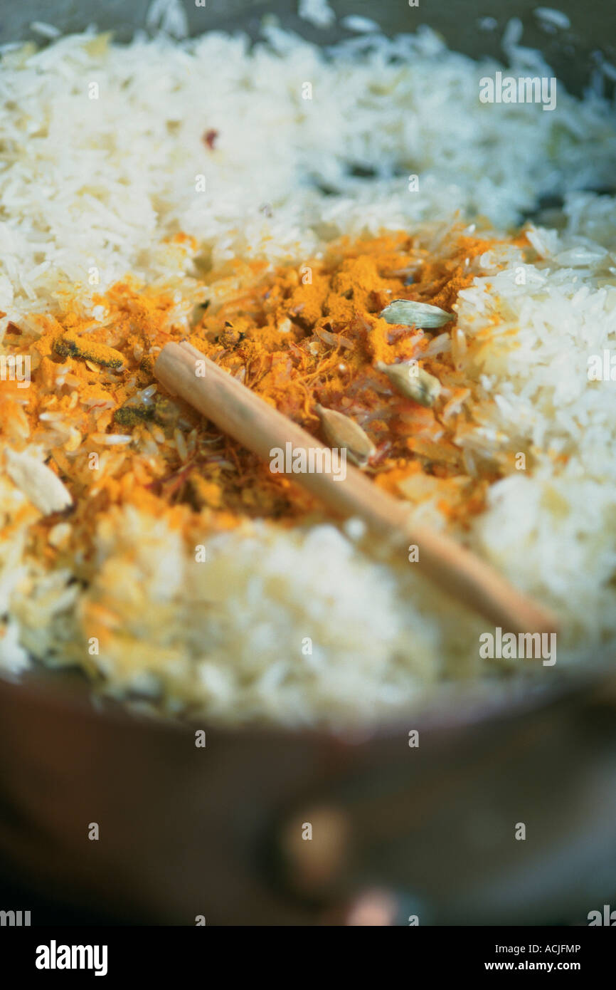 Riz au safran et cardamome dans la plaque de cuivre bâtonnet de bois Banque D'Images