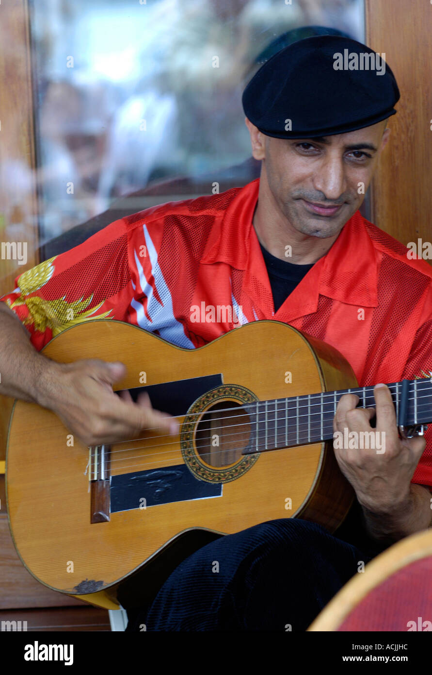 Le guitariste flamenco espagnol en chemise rouge et béret noir Banque D'Images