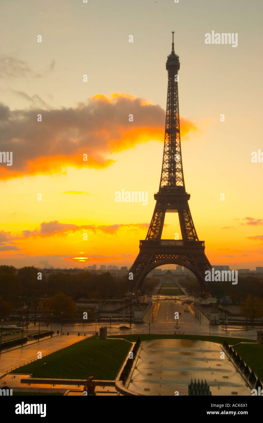 La Tour Eiffel à Paris au début de l'aube du matin avec le lever de soleil sur l'horizon, ciel bleu pâle quelques nuages blancs et le soleil jaune d'vu de la Place du Trocadéro square Paris France Banque D'Images