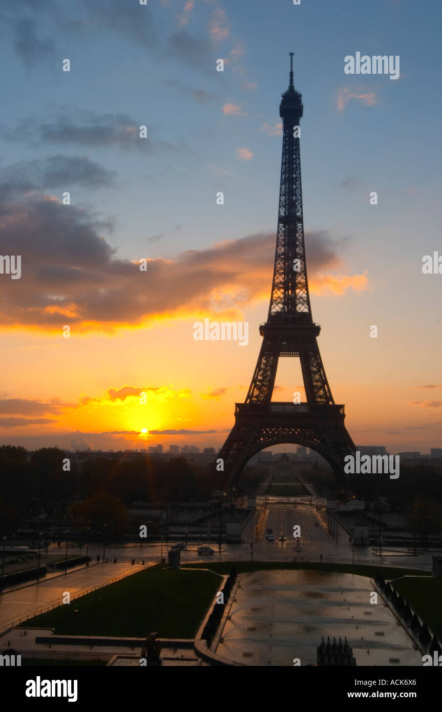 La Tour Eiffel à Paris au début de l'aube du matin avec le lever de soleil sur l'horizon, ciel bleu pâle quelques nuages blancs et le soleil jaune d'vu de la Place du Trocadéro square Paris France Banque D'Images