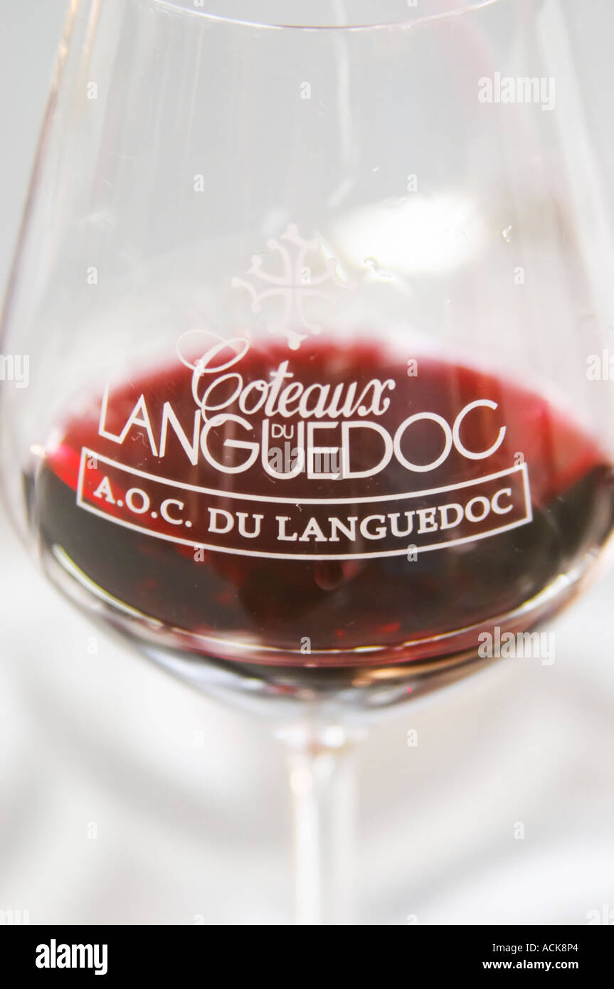 Verre de dégustation de vin sur un fond blanc rempli de vin rouge et gravé avec le texte Coteaux du Languedoc AOC du Languedoc Banque D'Images