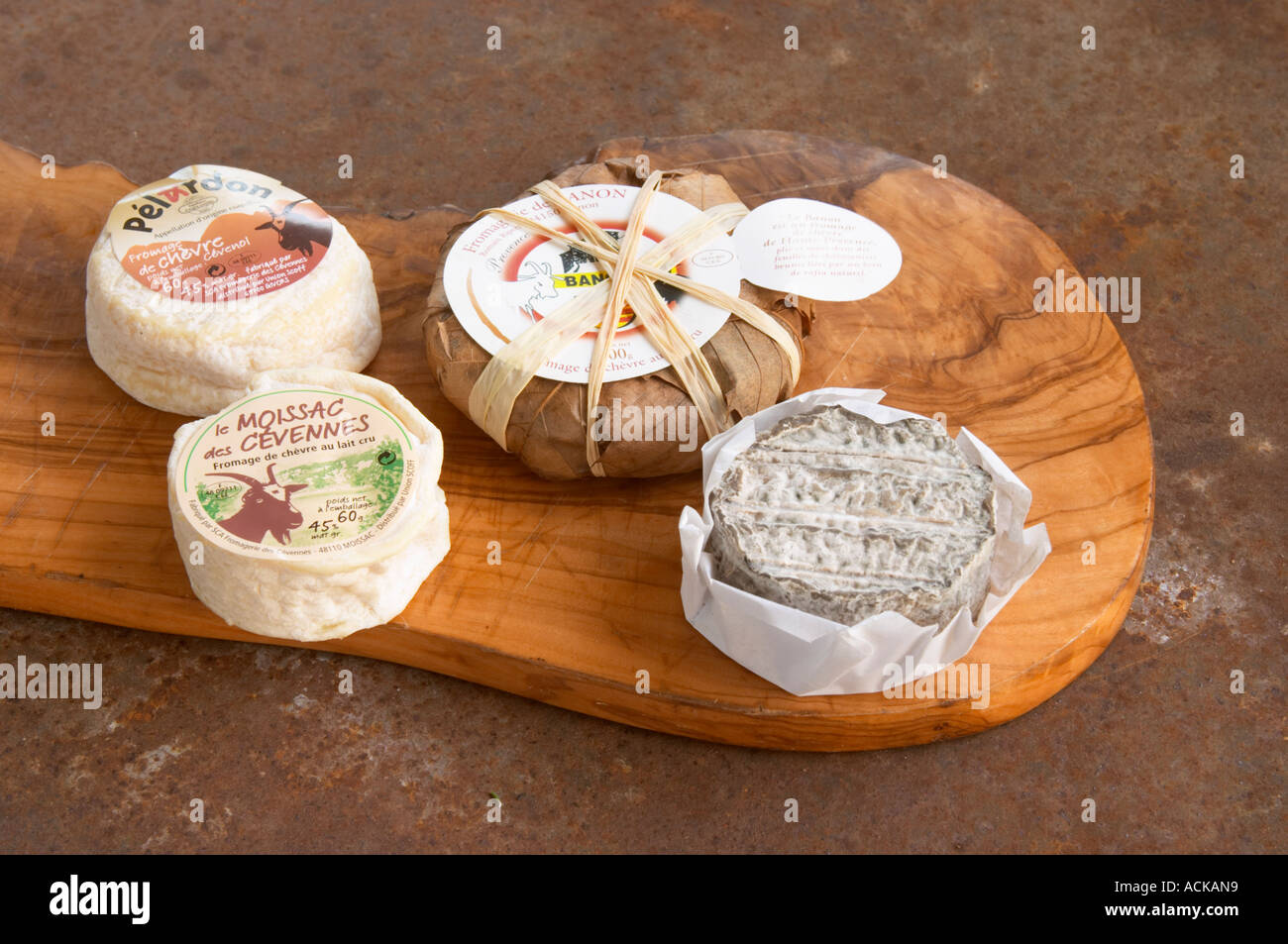 Sélection de fromage de chèvre - chevre - sur une planche à découper en  bois : ash (noir gris-ish), Moissac des Cévennes (avant gauche), Pelardon  (arrière gauche) et Banon (enveloppée dans les