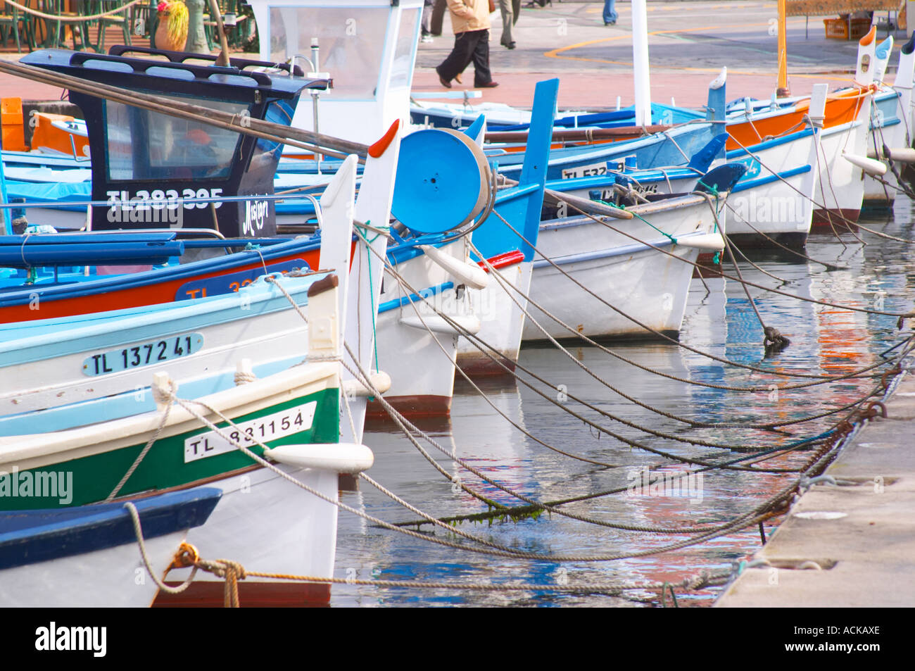 Les bateaux de pêche typiques provençales peints dans des couleurs blanc, bleu, vert rouge jaune, amarré au keyside Sanary Var Cote d'Azur France Banque D'Images