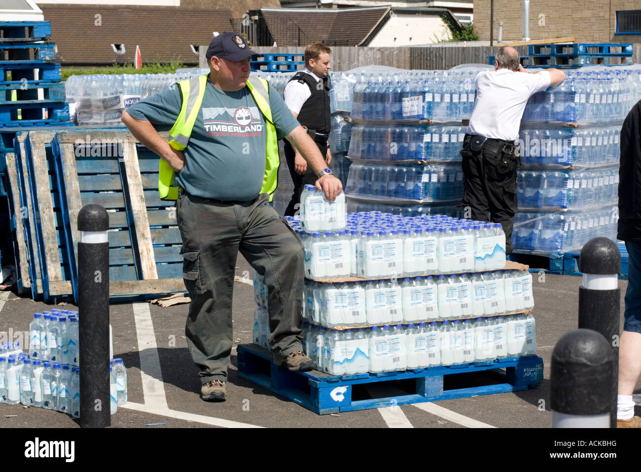 Homme avec palettes plastique bouteille d'eau UK Banque D'Images