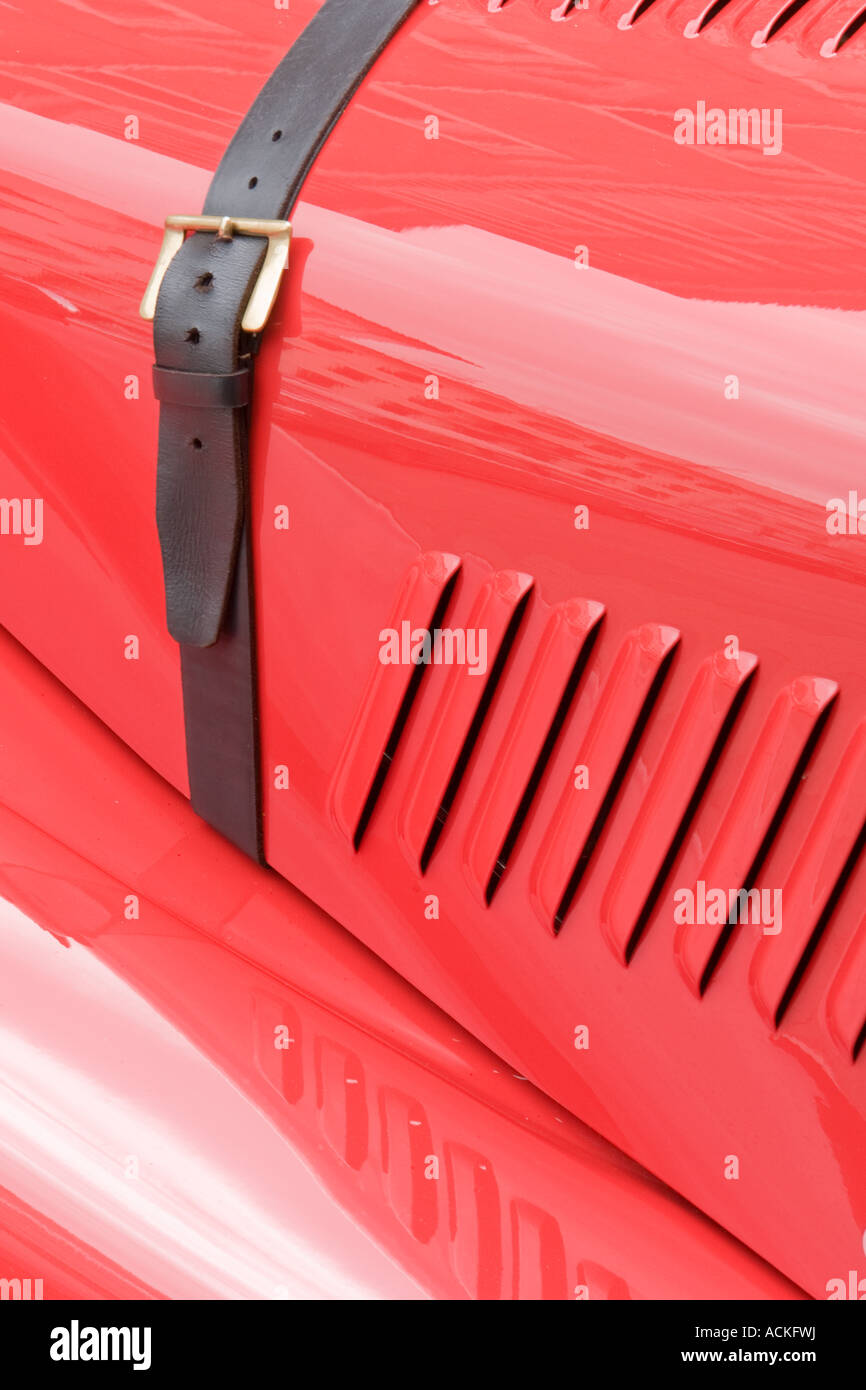 Capot de voiture rouge vif avec ceinture d tail holding le capot