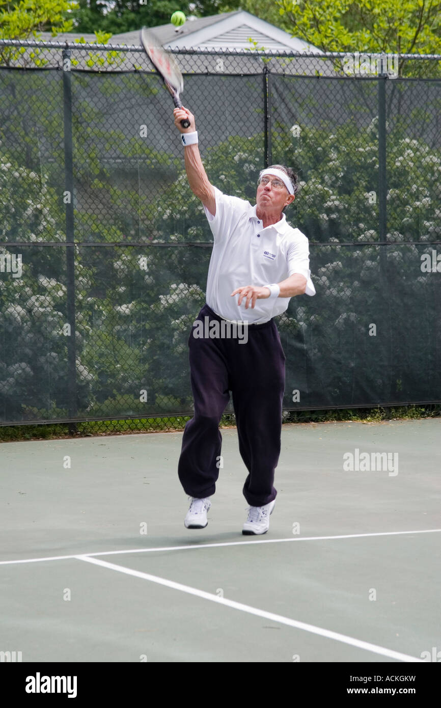 L'homme à la retraite âgé de 70 ans à jouer au tennis au service de la balle pour commencer le point pour le jeu Banque D'Images