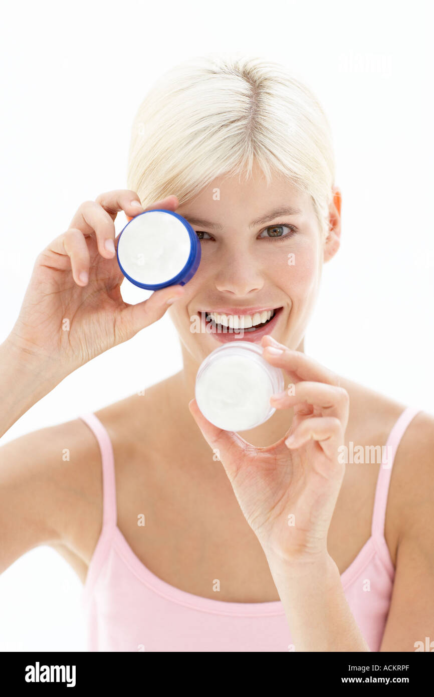 Une jeune femme jouant avec une bouteille de crème Banque D'Images
