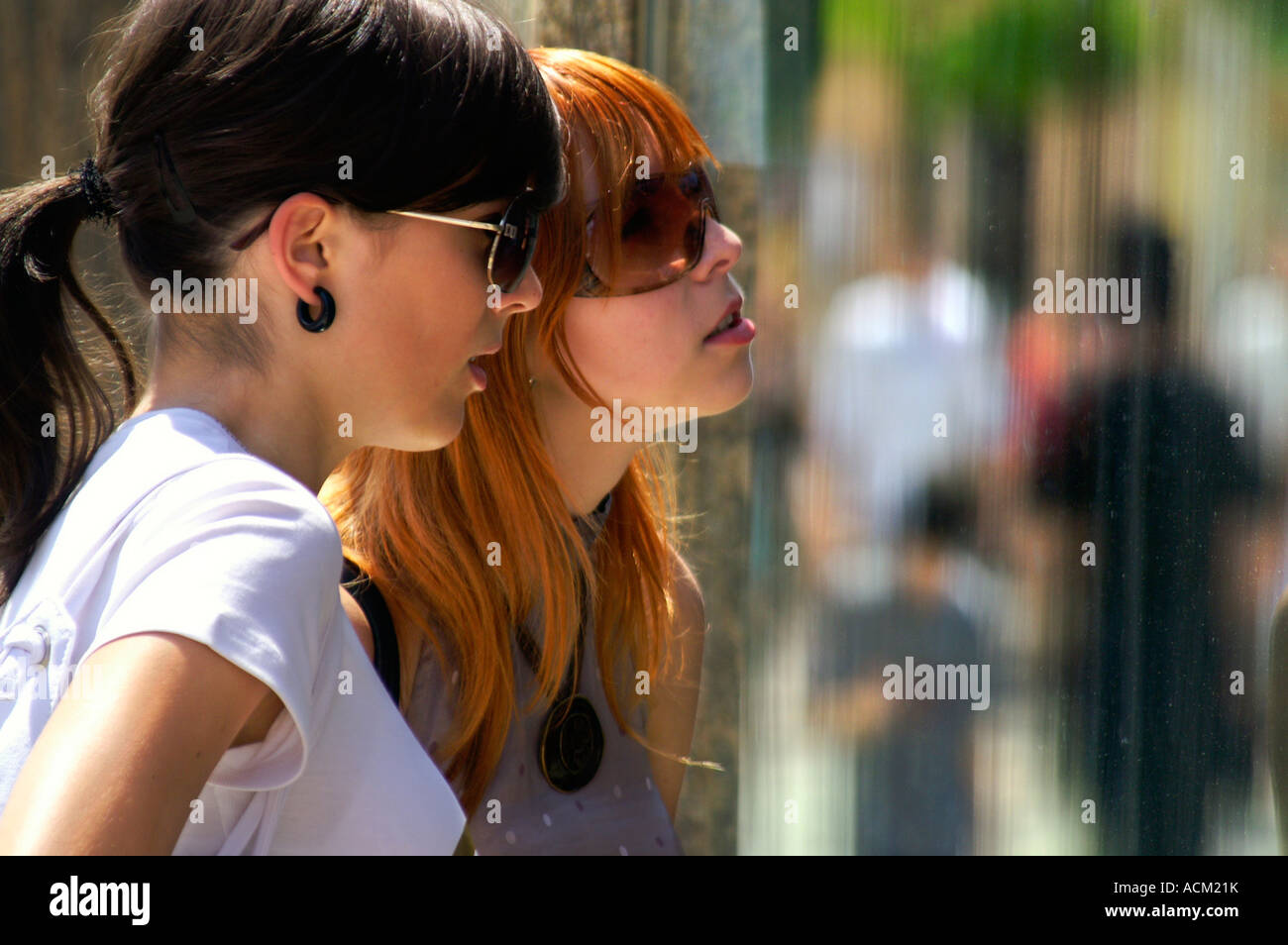 Deux jeunes filles devant un écran de fenêtre de boutique de mode Banque D'Images